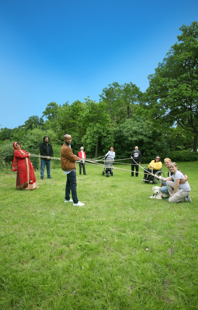 Menschen halten gemeinsam Fäden zu einem Netz
