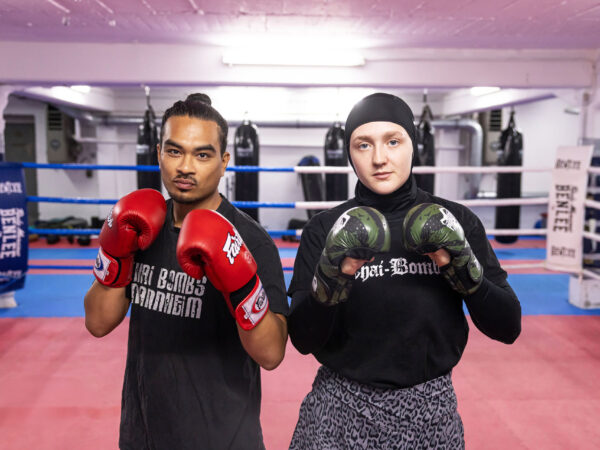 Simon und Malin stehen mit Boxhandschuhen im Boxring und schauen in die Kamera.
